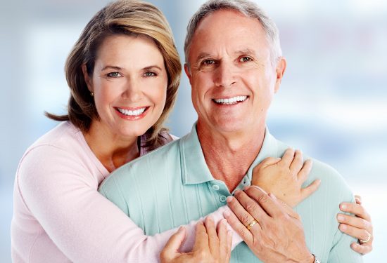 Happy senior couple portrait over blue background.